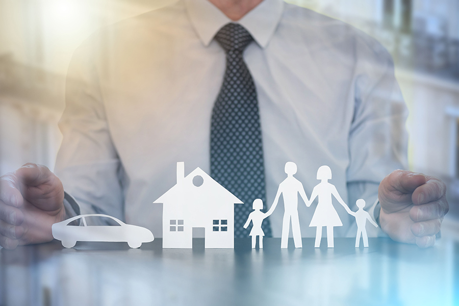 insurance agent with paper cutted images of properties family and car montpelier oh